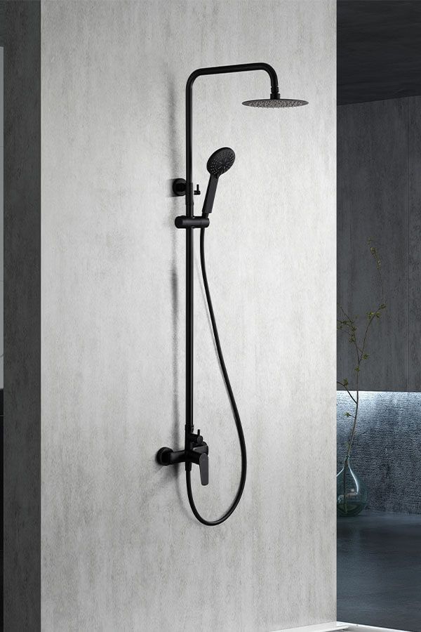 Sistema de ducha negro montado en una pared gris; cuenta con un cabezal de ducha de lluvia, una ducha de mano y un grifo.
