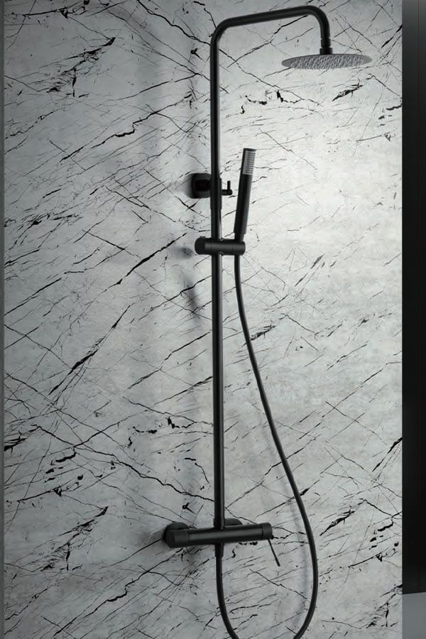 Sistema de ducha negro sobre una pared con diseño de mármol. Incluye cabezal de ducha tipo lluvia, ducha de mano y control de temperatura.