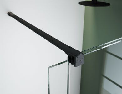 Barra de ducha negra montada entre la pared y el panel de ducha de vidrio.