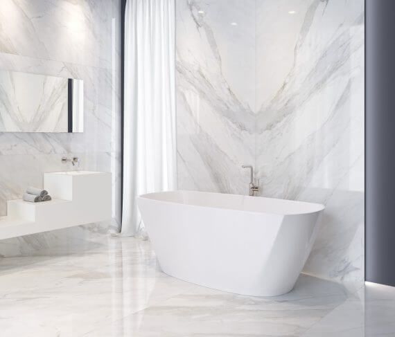 Lujoso baño blanco con paredes de mármol y bañera independiente.