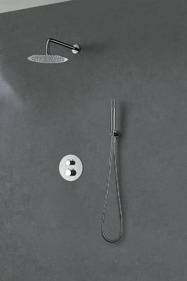 Accesorios de ducha en una pared gris: un cabezal de ducha de lluvia redondo, una ducha de mano y un panel de control circular.