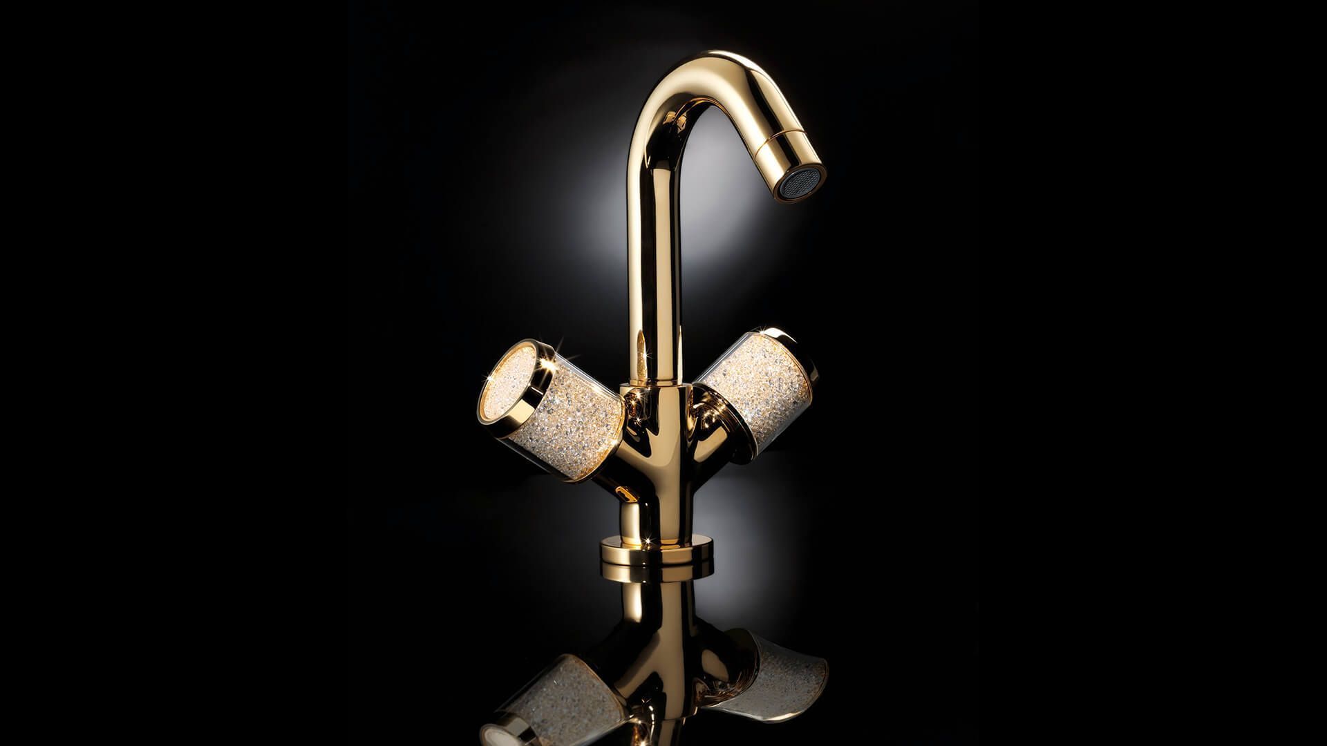 Grifo dorado con dos manijas redondas sobre fondo negro.