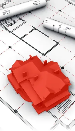 Maqueta de casa roja sobre planos arquitectónicos con planos enrollados.