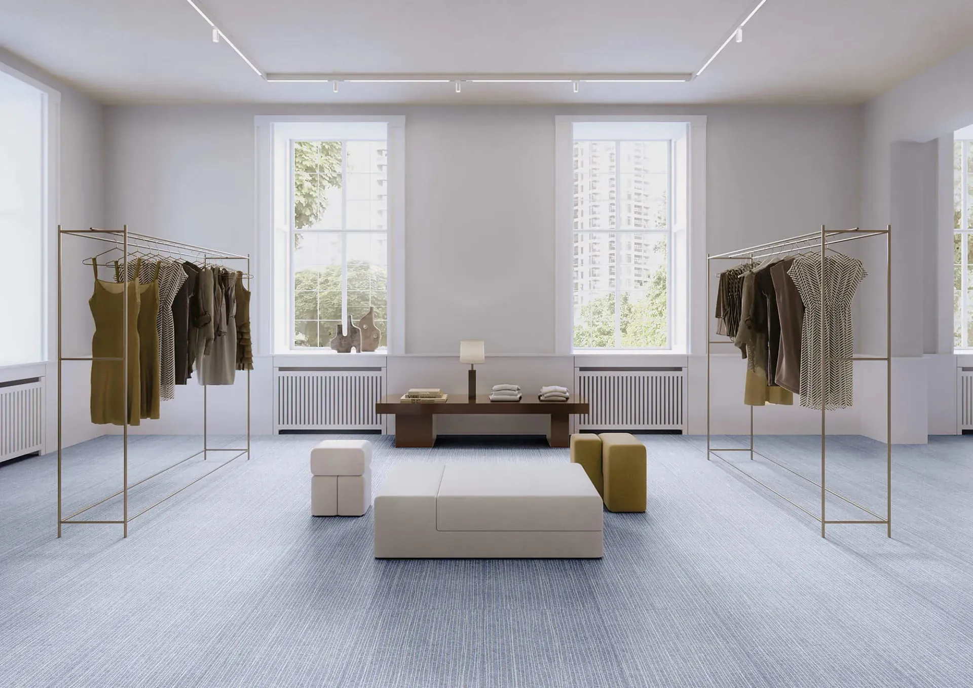 Interior de una tienda de ropa con percheros, un banco y ventanas. Suelo con estampado azul claro.