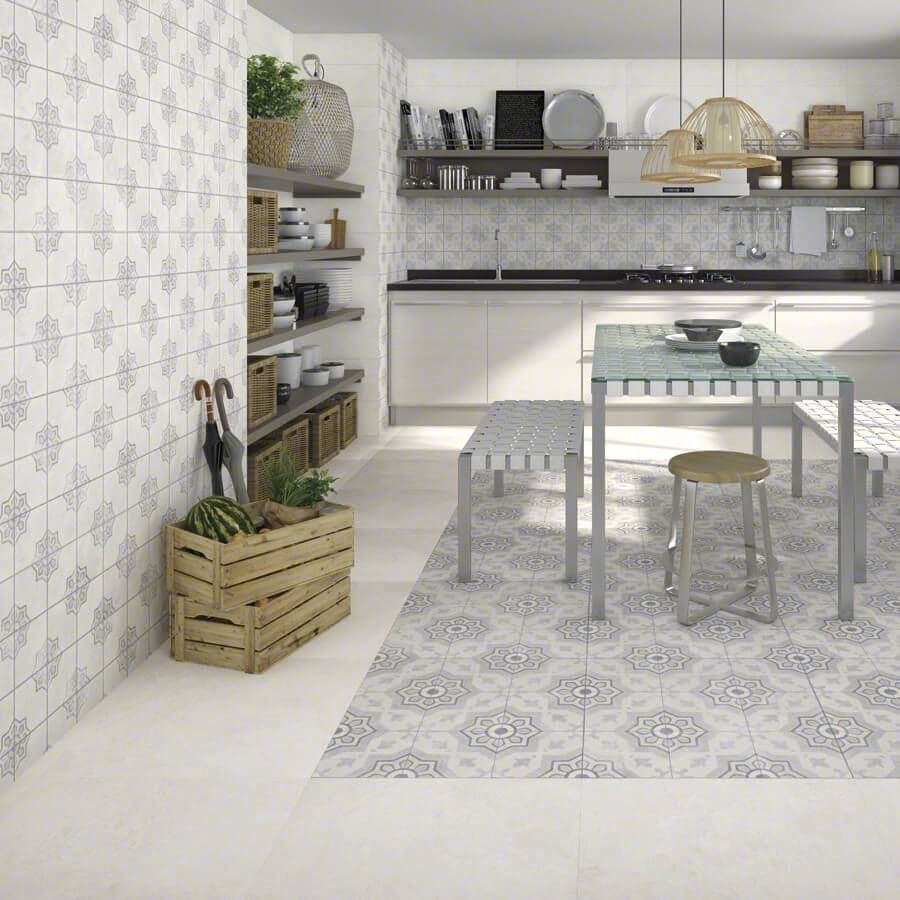 Cocina con azulejos estampados, cajón de madera, estantes y una mesa.