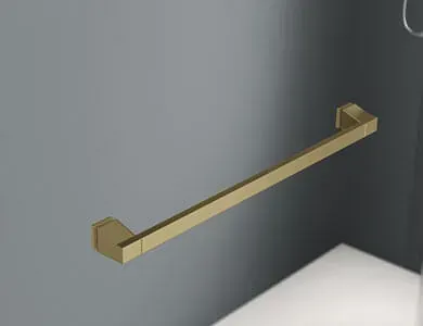 Barra de toalla rectangular de color dorado montada en una pared de baño gris, sobre una superficie blanca.