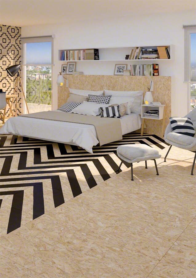 Dormitorio con alfombra de chevron en blanco y negro, cabecero de madera y suelo de baldosas beige.