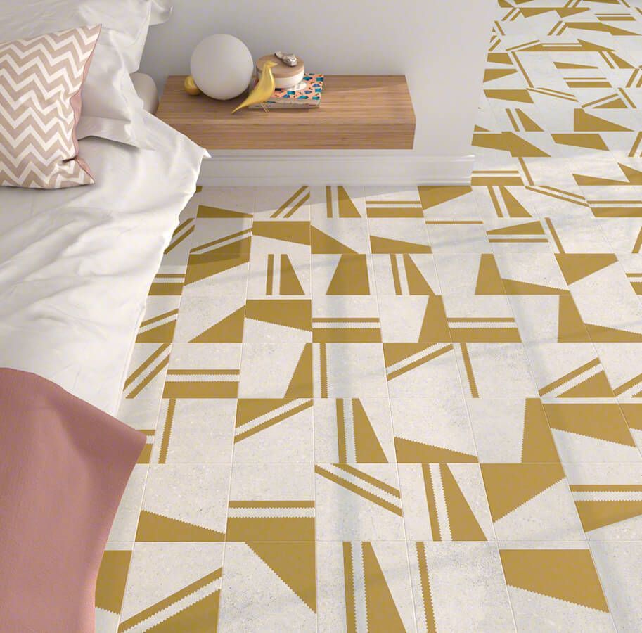 Dormitorio con ropa de cama blanca, mesita de noche de madera y suelo de baldosas con dibujos en amarillo y blanco.