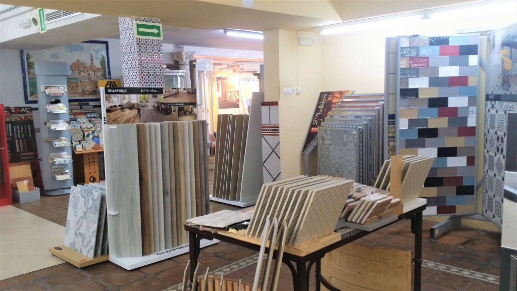 Interior de sala de exposición de azulejos, que muestra varias muestras de azulejos para pisos y paredes.