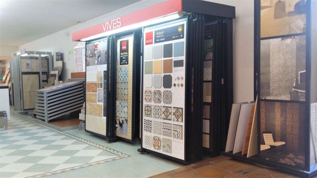 Exhibición de azulejos en una tienda, con diversos colores y estampados. Foto interior con suelo a cuadros.