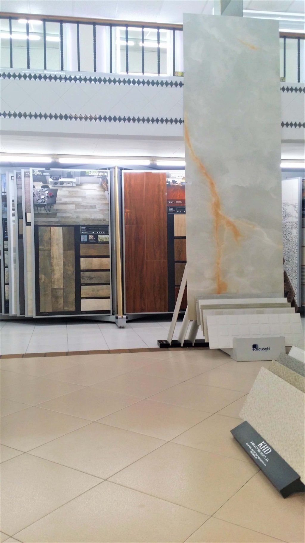 Sala de exposición de azulejos con gran exposición de diversos azulejos, incluidos los de aspecto madera y aspecto mármol.