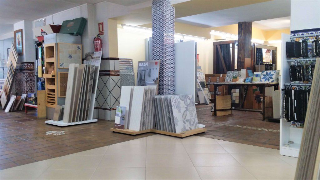 Interior de una tienda de azulejos, donde se muestran diversas muestras de azulejos y accesorios.