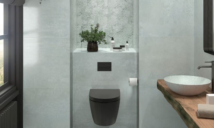 Baño moderno con inodoro oscuro, paredes de piedra y lavabo con cubierta de madera.