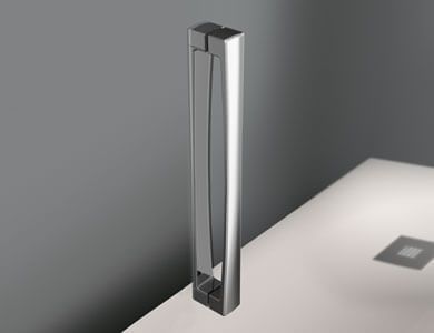 Manija de puerta de ducha de color plata brillante contra una pared gris y una superficie blanca.