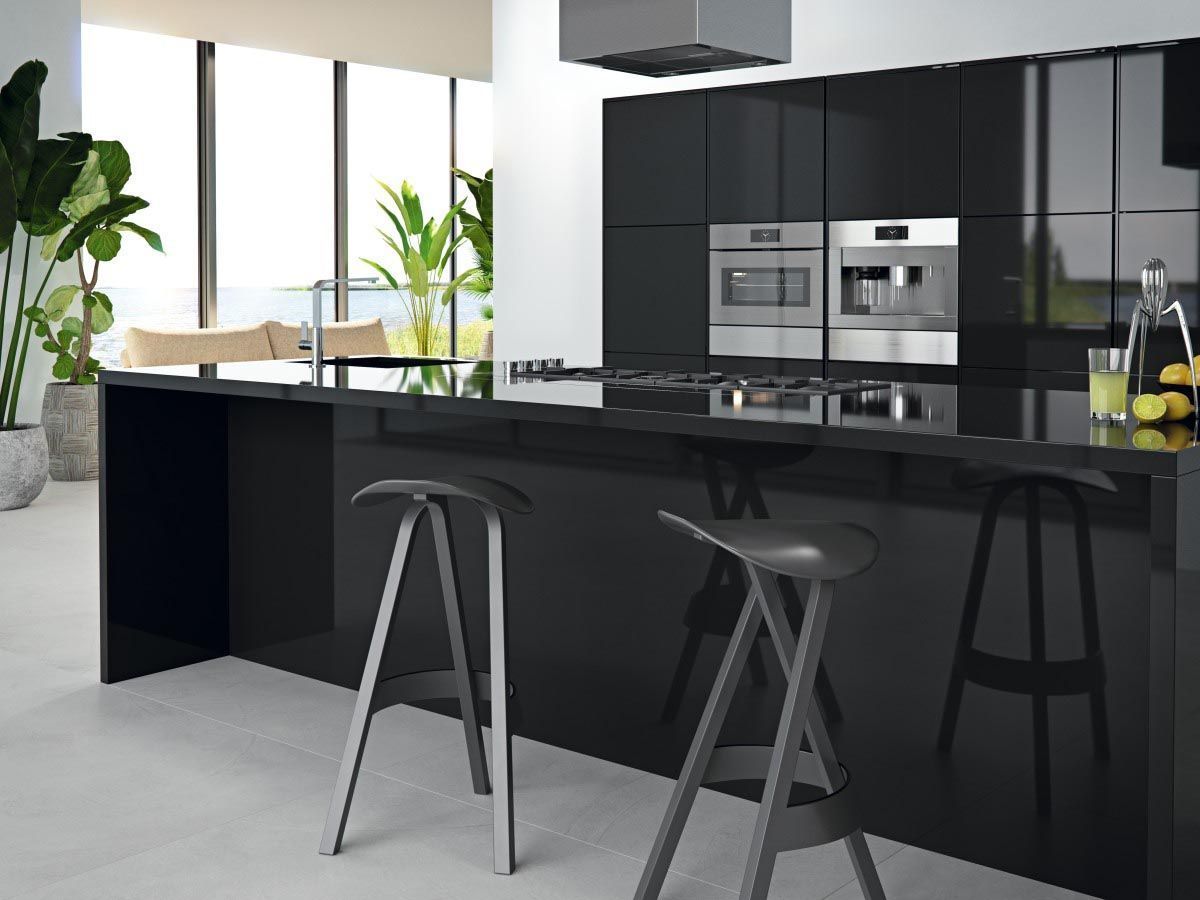 Cocina moderna en negro con gabinetes de alto brillo, isla y electrodomésticos de acero inoxidable. Dos taburetes en la isla.
