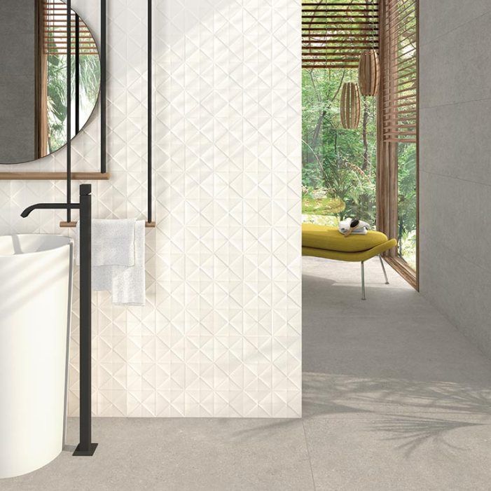 Baño moderno con pared de azulejos triangulares blancos, grifo negro, espejo redondo y vista al exterior.
