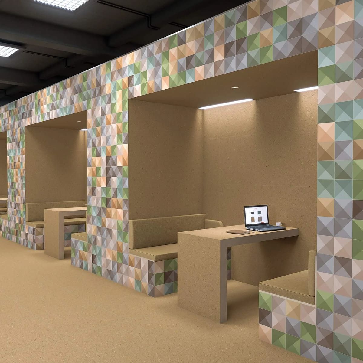 Cubículos de oficina con detalles de azulejos geométricos y escritorios y bancos incorporados.
