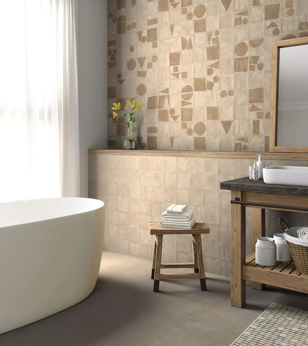 Baño con pared estampada en color beige, bañera blanca, tocador de madera y taburete.