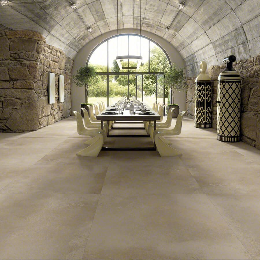 Elegante comedor con techo abovedado, mesa larga, paredes de piedra y vista al jardín.