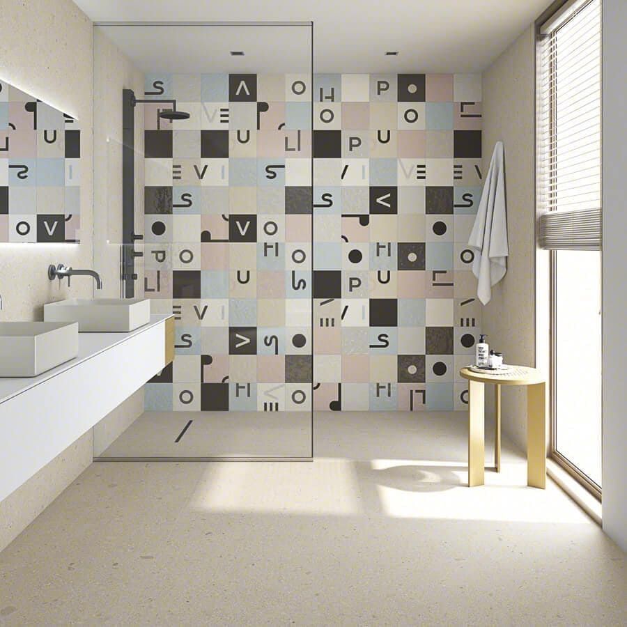 Baño moderno con pared de azulejos estampados, ducha de cristal y diseño minimalista.