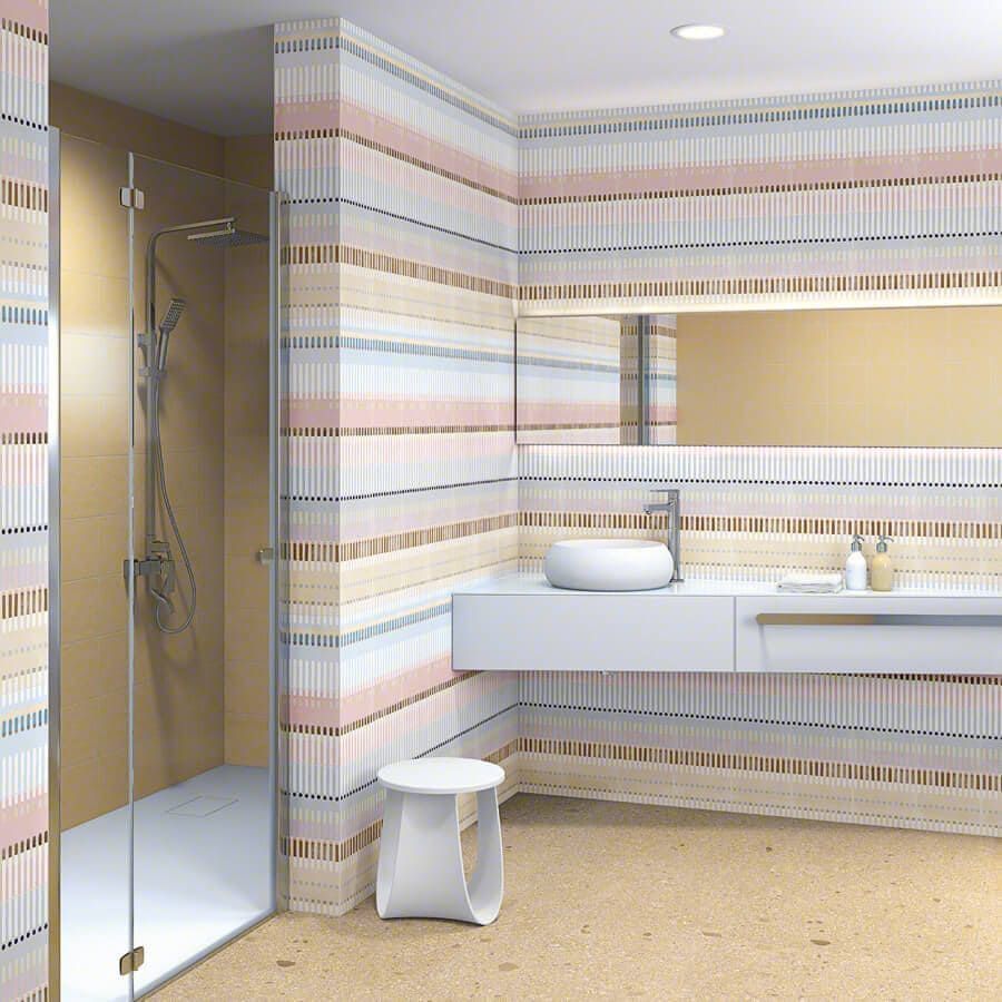Baño moderno con paredes de azulejos en tonos pastel a rayas, tocador flotante blanco y ducha de vidrio.
