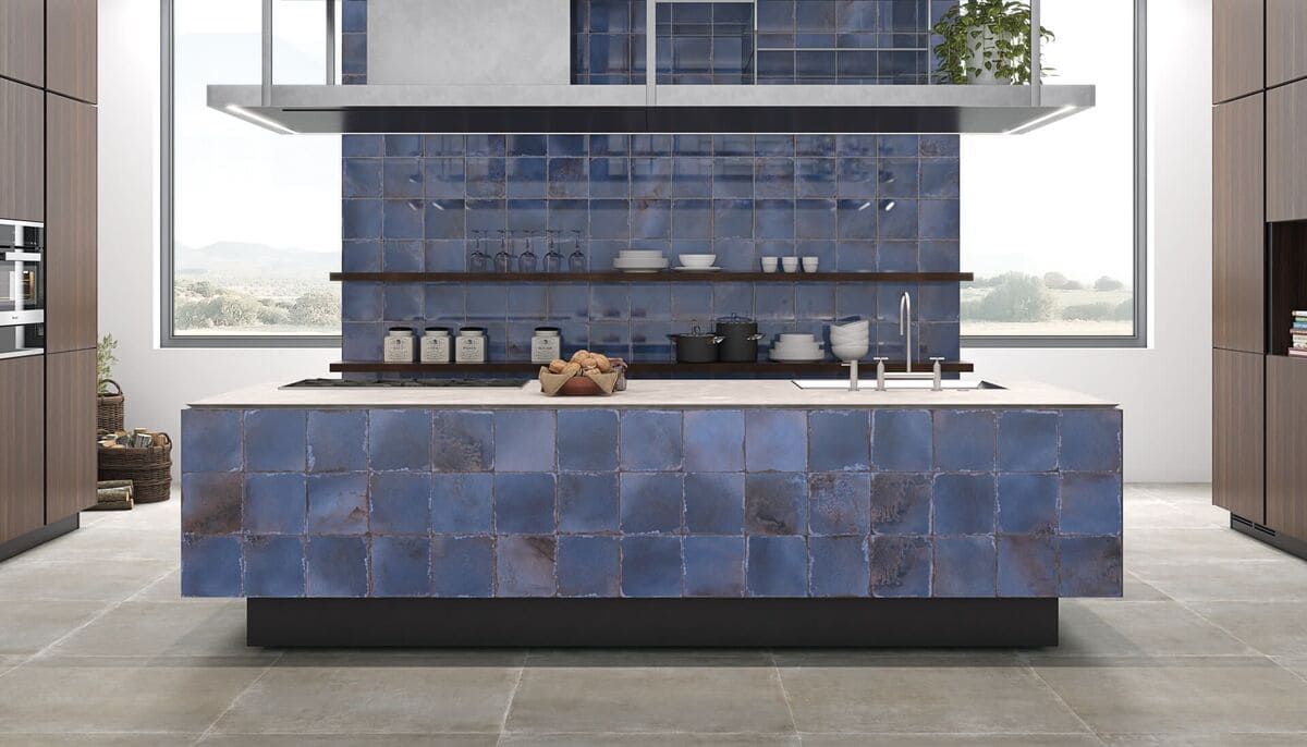 Cocina moderna con isla y protector contra salpicaduras de azulejos azules, gabinetes marrones y una ventana grande con vista a un paisaje.