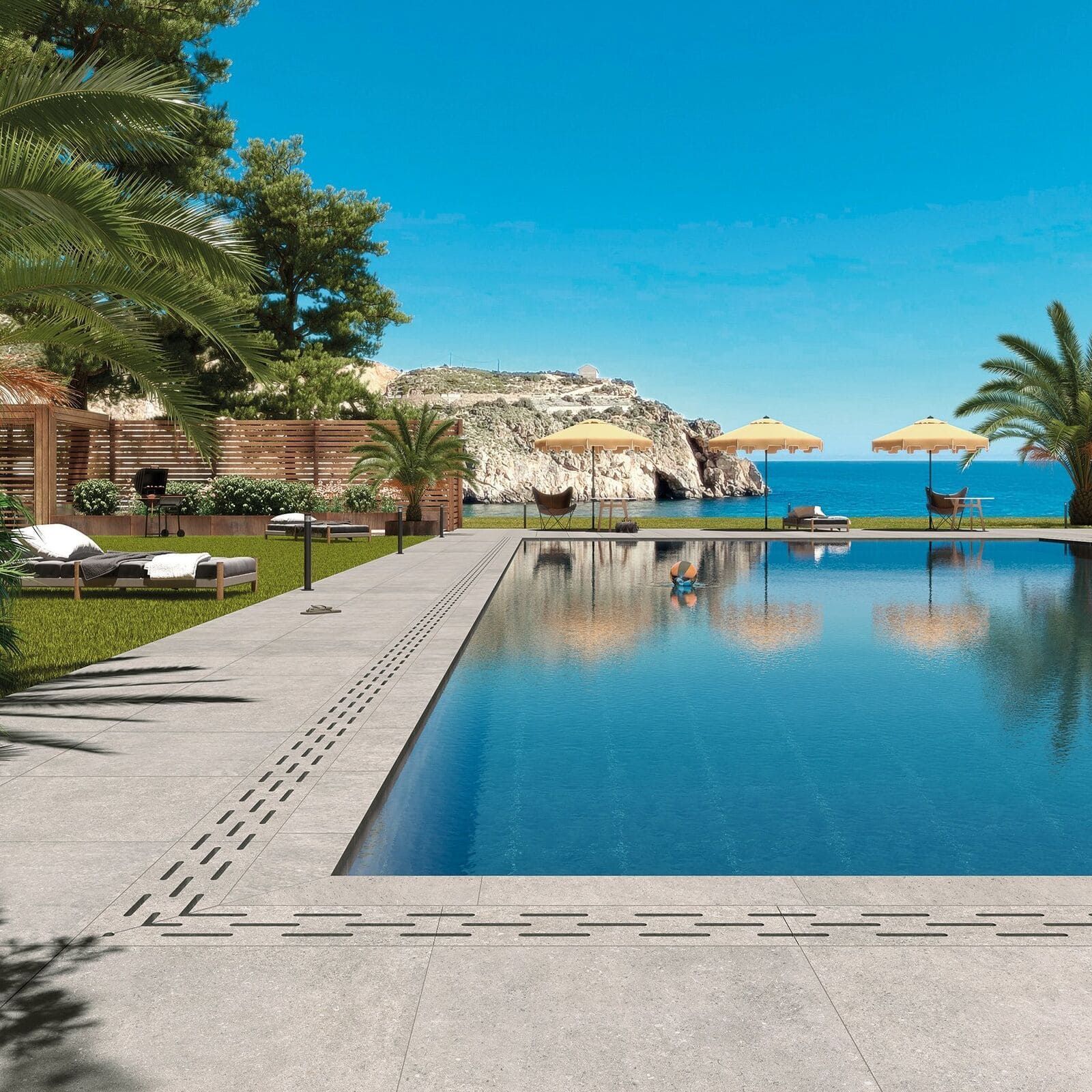 Una lujosa piscina con vista al mar, palmeras y tumbonas en un día soleado.