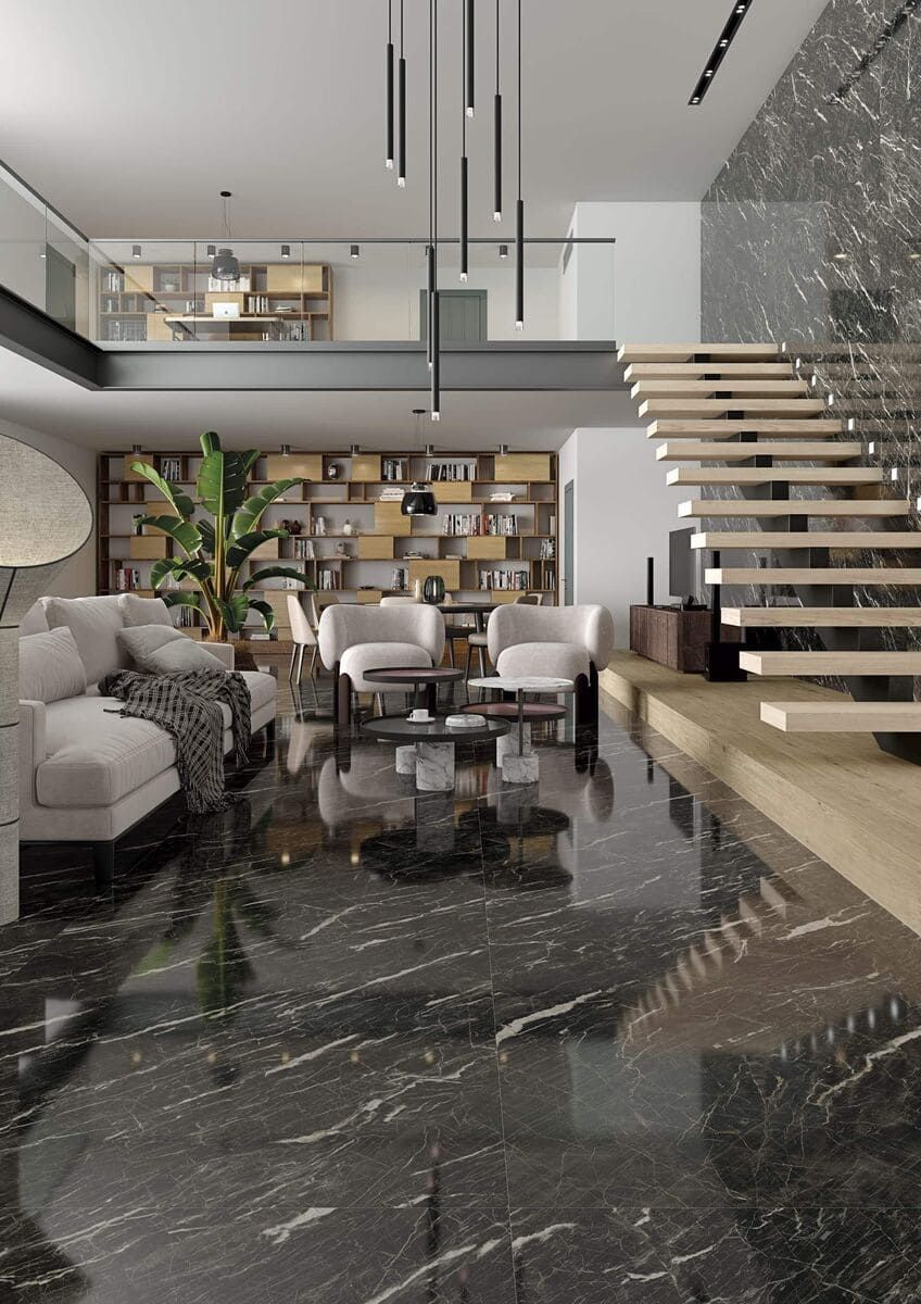 Lujosa sala de estar con piso de mármol negro, escalera y muebles modernos.