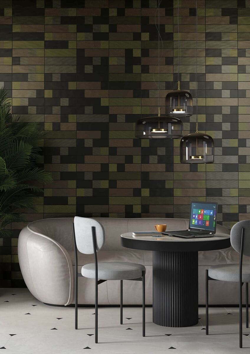 Comedor moderno con pared estampada en verde, mesa redonda, sillas y lámparas colgantes.