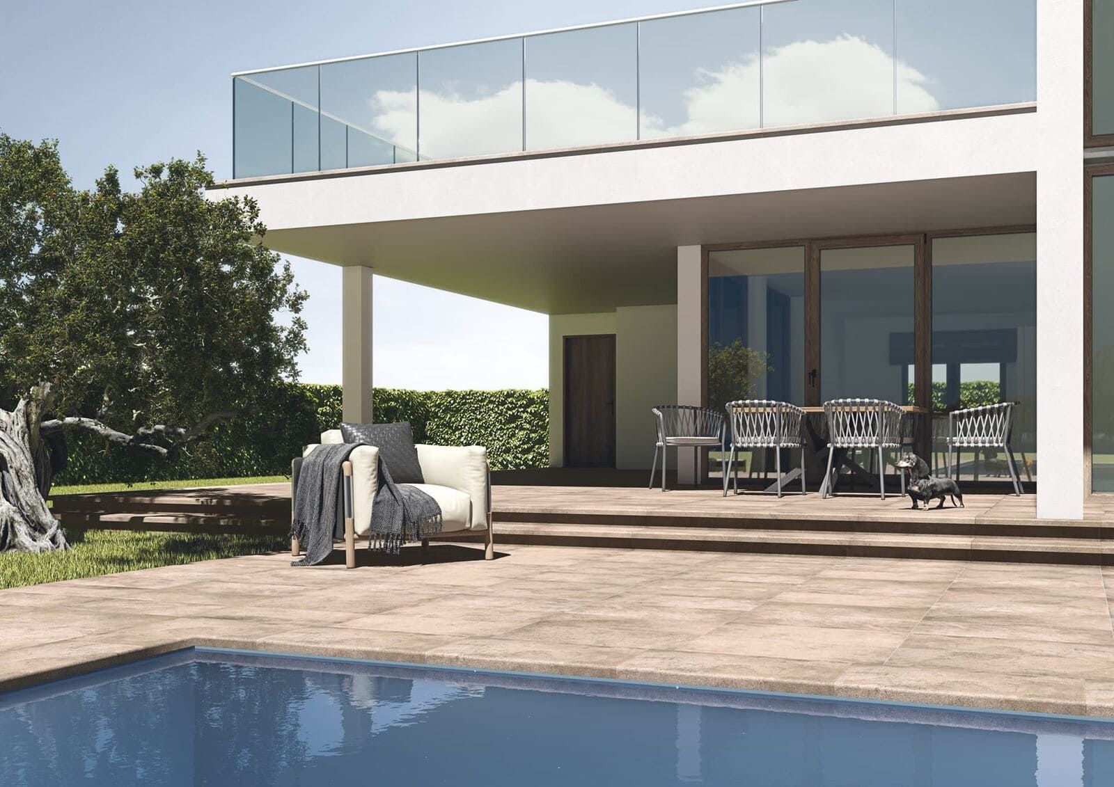 Patio junto a la piscina de una casa moderna con barandillas de cristal, muebles de exterior y piscina. Día soleado.