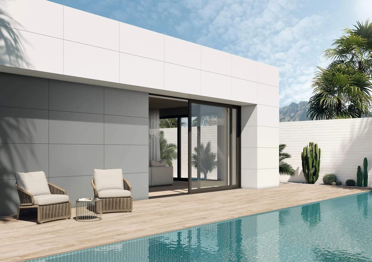 Casa moderna con piscina, puertas corredizas de vidrio, muebles de patio y agua azul.