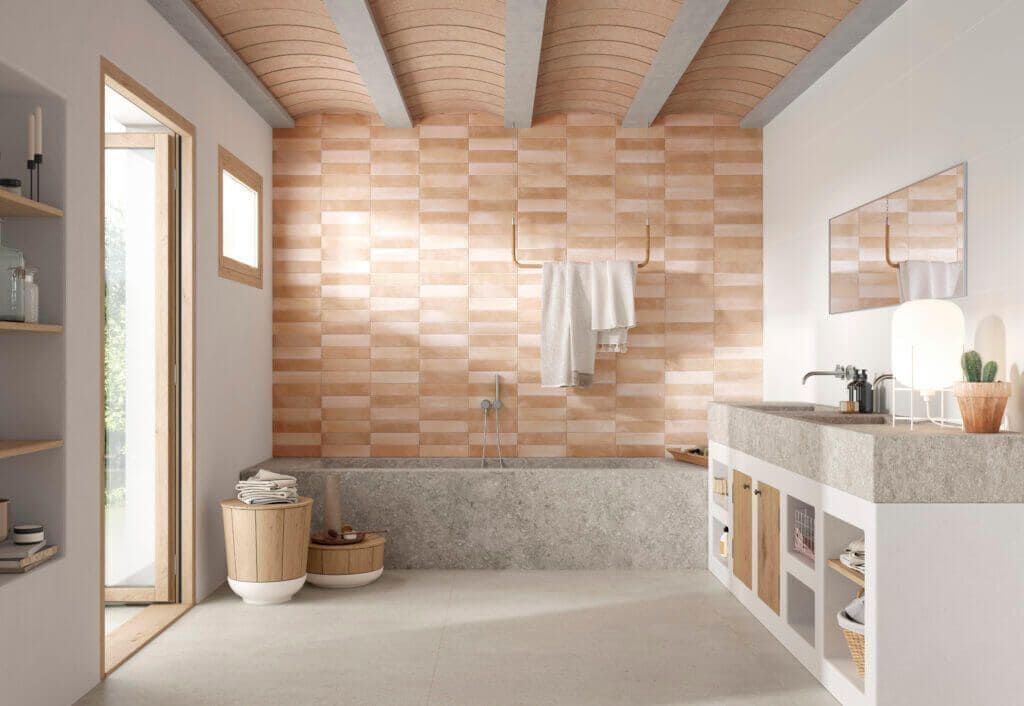 Baño con paredes beige claro, bañera y encimera de hormigón. Pared y techo con azulejos naranjas.