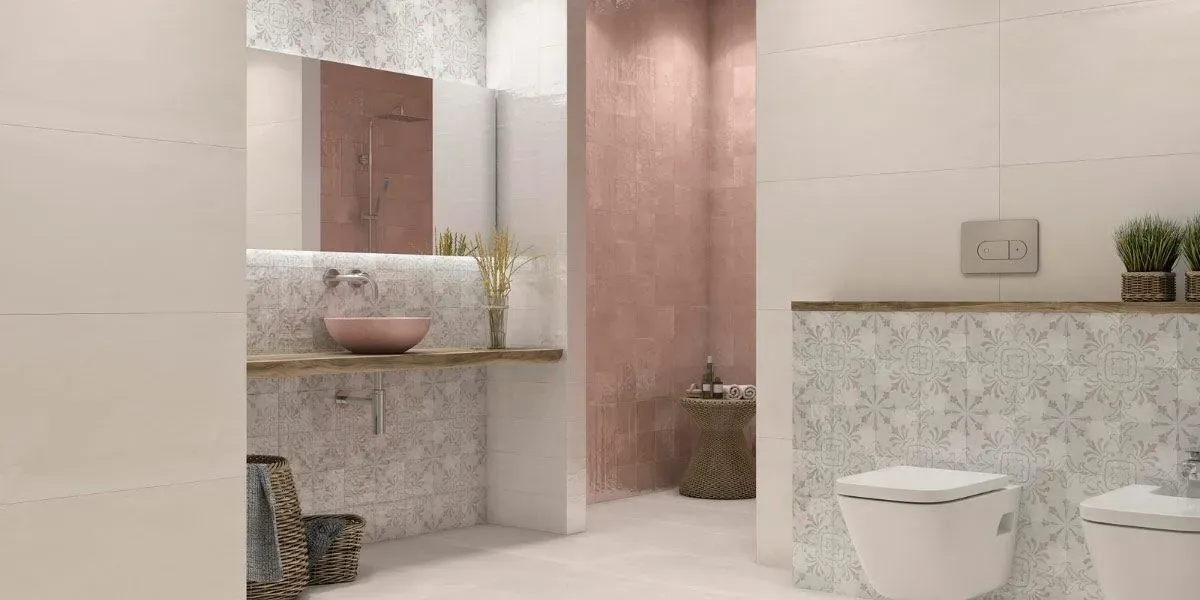 Baño moderno en tonos rosa claro y gris, con inodoro, lavabo y plantas decorativas.