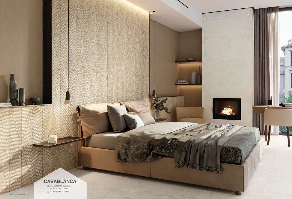 Un dormitorio en tonos neutros con una pared texturizada, cama, chimenea y una ventana que da a un edificio.