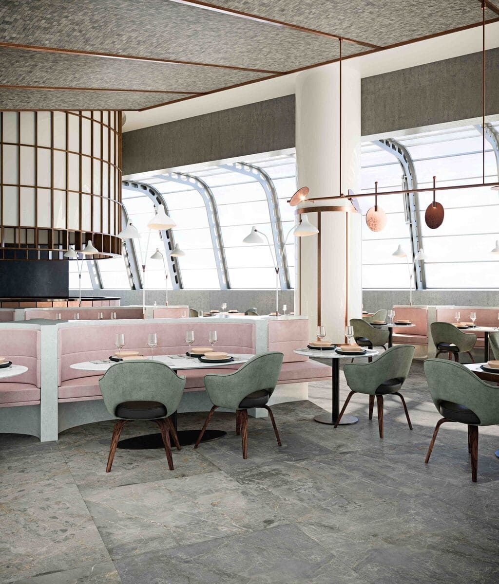 Interior de restaurante con cabinas rosas, sillas verdes, ventanas arqueadas y detalles de cobre.