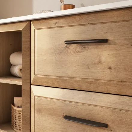 Mueble de baño de madera con estantes abiertos y dos cajones, tiradores negros.