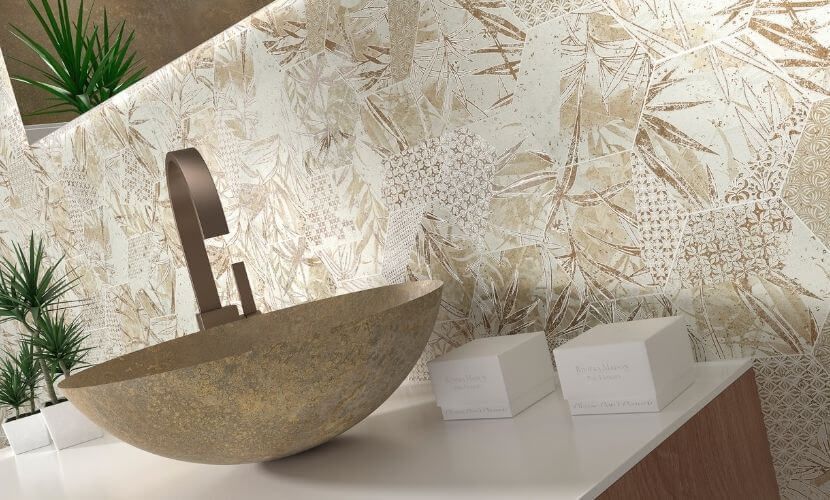 Lavabo de baño con grifo de bronce y salpicadero de azulejos estampados de color beige.