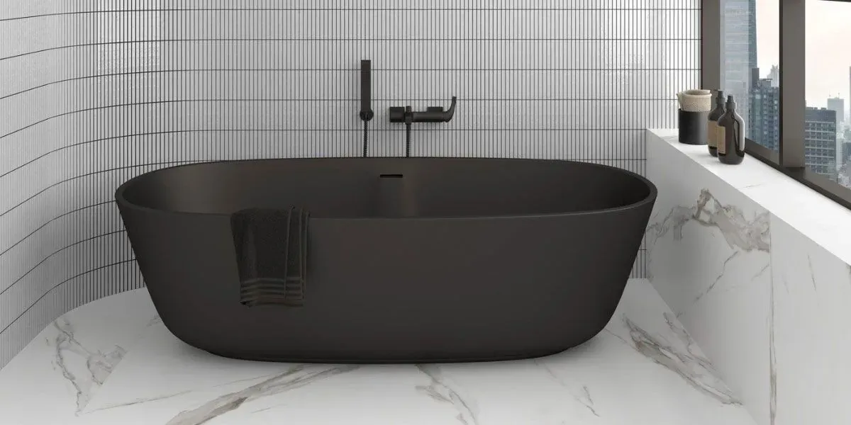 Bañera negra en un baño moderno con azulejos de mármol blanco y vista a la ciudad.