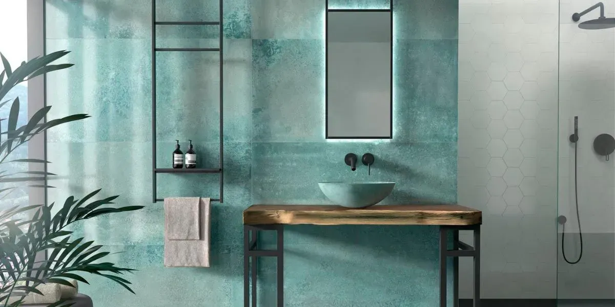 Baño moderno con azulejos turquesa, tocador de madera y espejo grande.