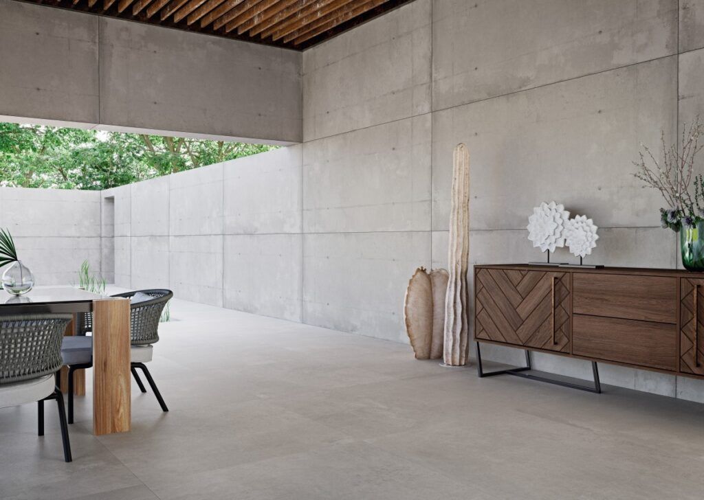 Patio exterior con paredes de hormigón, techo de madera y juego de comedor. Incluye armarios de madera y elementos decorativos.