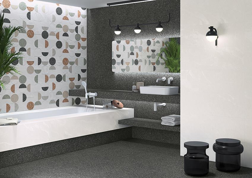 Baño moderno con azulejos de pared estampados, bañera, lavabo y suelo gris oscuro.
