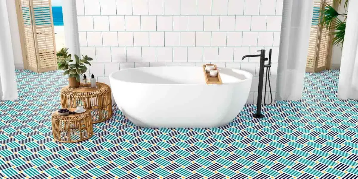 Baño con suelo estampado en azul y blanco, bañera y paredes blancas y grifería negra.