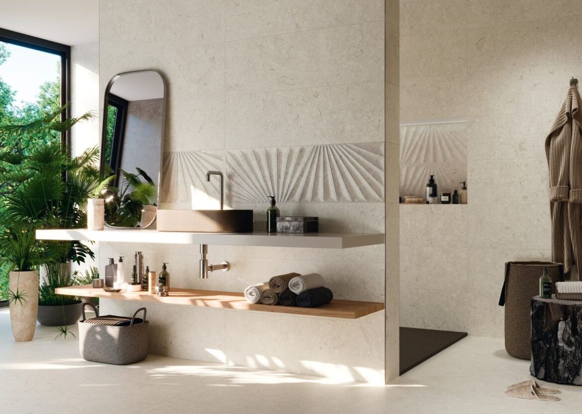 Baño moderno con paredes texturizadas en tono beige, estantes flotantes, lavabo negro y un gran ventanal con vegetación.