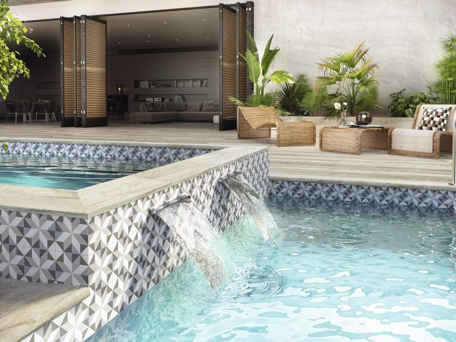 Piscina con cascada de azulejos, asientos en el patio y puertas abiertas al interior.