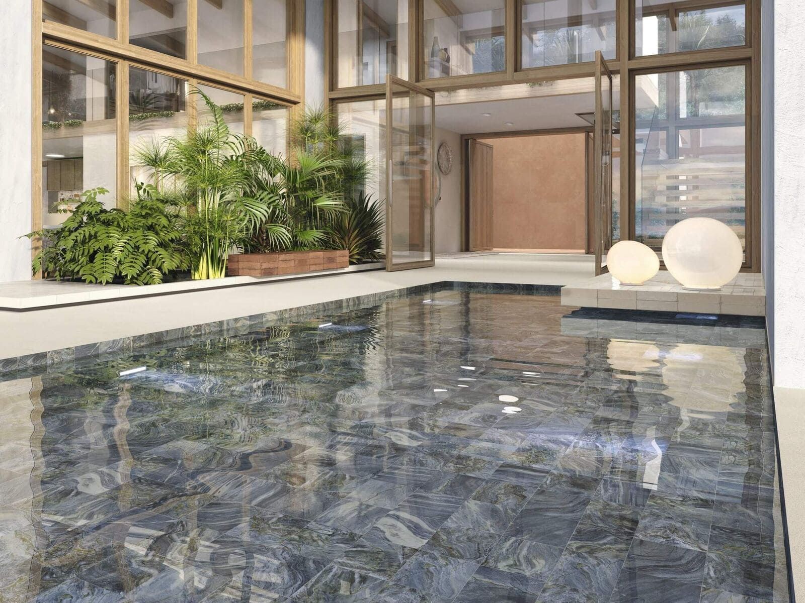 Piscina que refleja un edificio al aire libre con paredes de cristal, vegetación y tonos neutros.