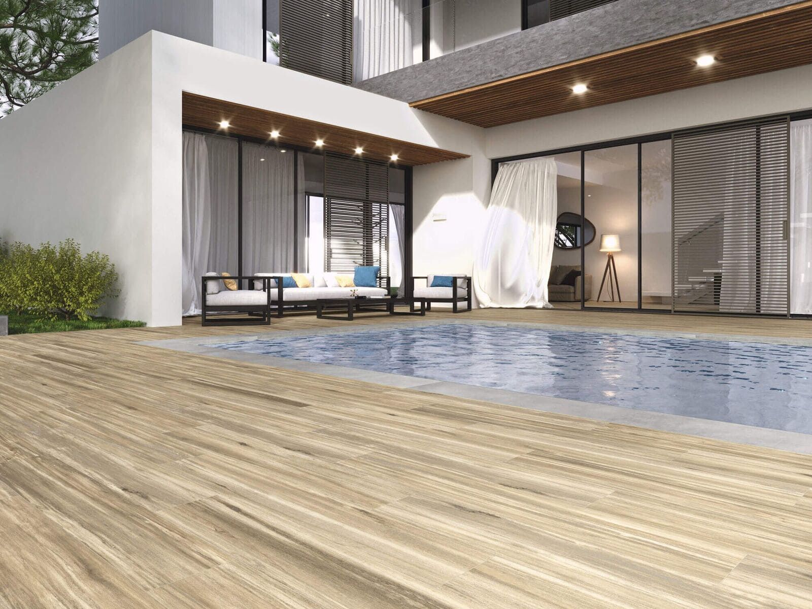 Una terraza de madera conduce a una piscina junto a una moderna casa blanca con puertas de vidrio y un patio cubierto.