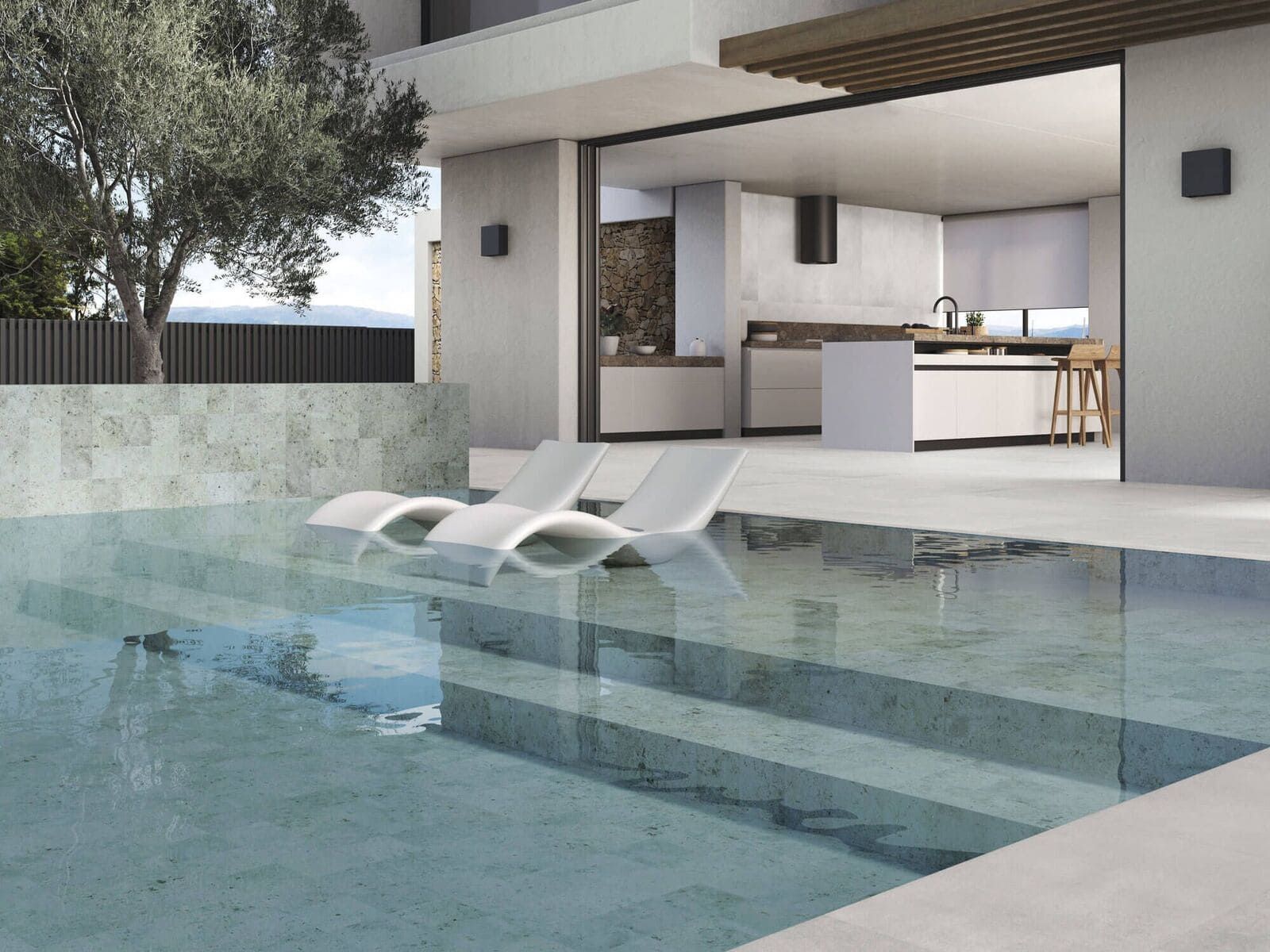 Baño beige con azulejos de piedra, un jarrón de pedestal y una bañera al fondo.