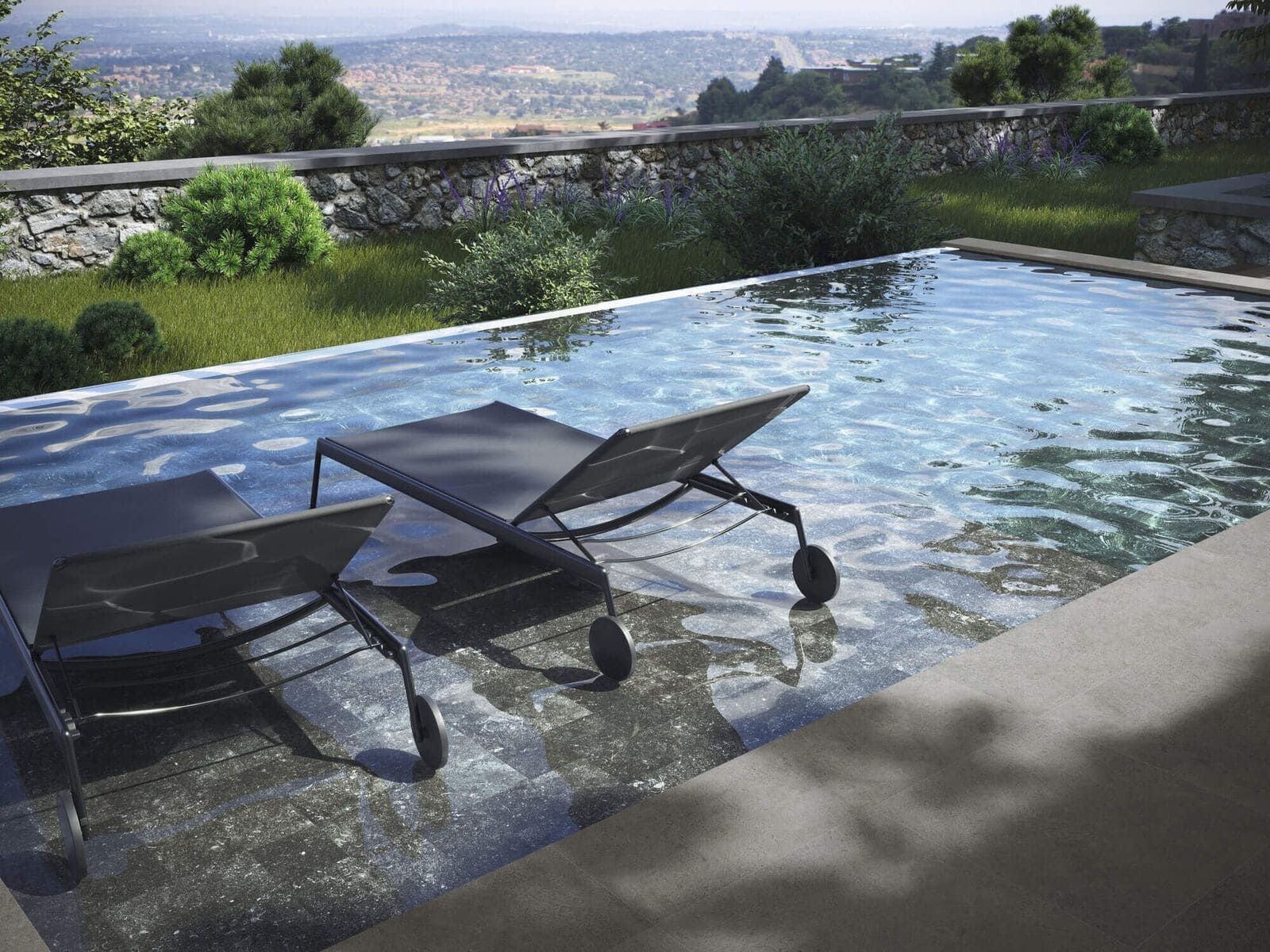 Dos tumbonas negras junto a una piscina con una vista panorámica de fondo.