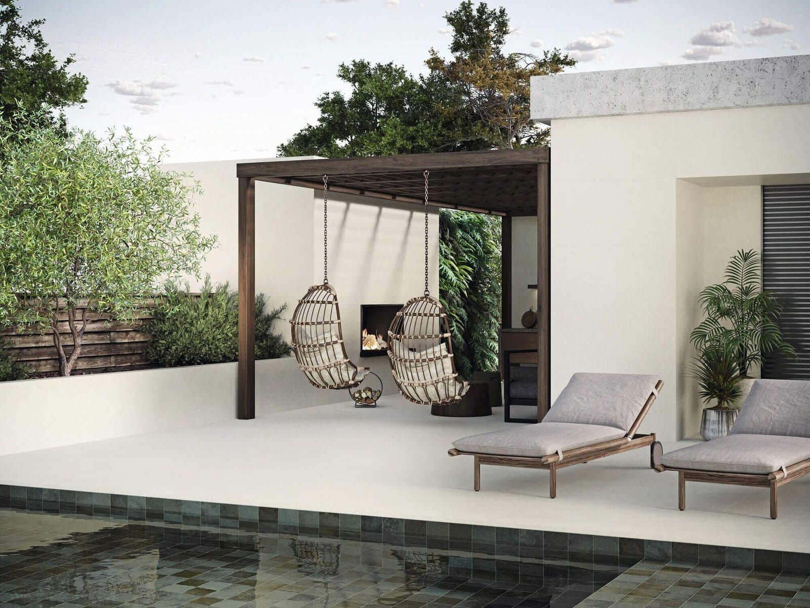 Patio exterior con sillas colgantes, tumbonas y una pequeña piscina.