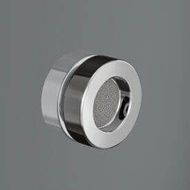 Tirador de gabinete circular con acabado cromado y agarre para los dedos empotrado sobre un fondo gris.